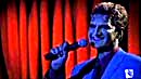 Lorne singing, lit by the stagelights