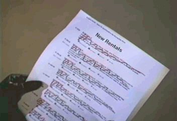 Buffy's gloved hands holding a piece of paper labelled "New Rentals". Many are scribbled out.